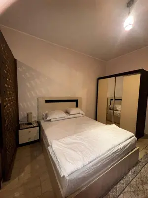 a bedroom with a large bed with white sheets at Aldau heights Hurghada in Hurghada