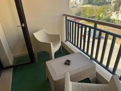 a room with a balcony with a table and chairs at Aldau heights Hurghada in Hurghada