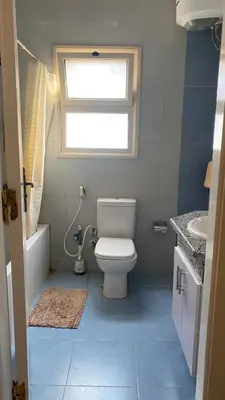 a bathroom with a toilet and a sink and a window at Sea view 3 bedrooms apartment 06 in Hurghada