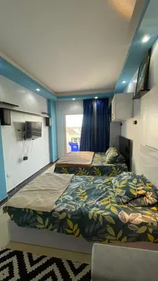 two beds in a room with blue walls at سيسليا بيتش ريزورت in Hurghada
