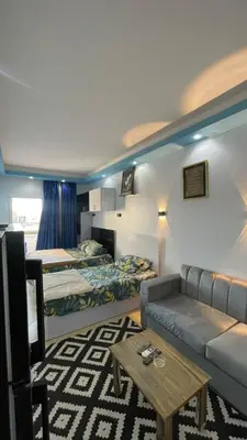 a room with two beds and a couch and a table at سيسليا بيتش ريزورت in Hurghada