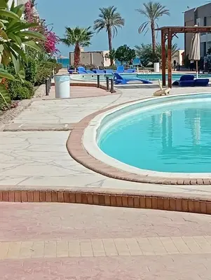 a swimming pool at a resort with palm trees at سيسليا بيتش ريزورت in Hurghada
