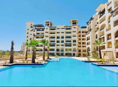 a hotel with a large swimming pool in front of a building at Aldau heights Hurghada in Hurghada