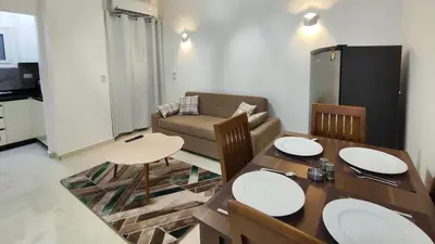 a living room with a table and a couch at Comfort quiet central new flat in Hurghada