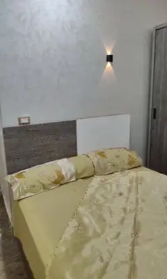 a bed in a bedroom with a light above it at الغردقة منطقه عربيا شارع العشريني بجوار كافية فيلو in Hurghada