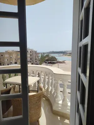 a balcony with a table and a view of the beach at Antique apartment with sea view in Hurghada