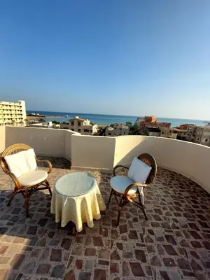 a patio with chairs and a table on a roof at Antique apartment with sea view in Hurghada