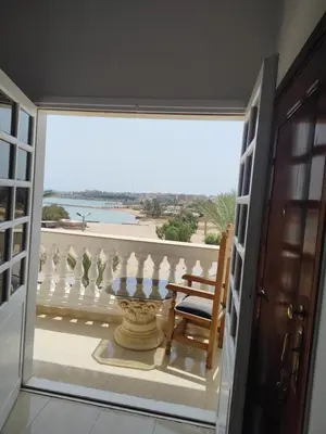 a room with a balcony with a chair and a view at Antique apartment with sea view in Hurghada