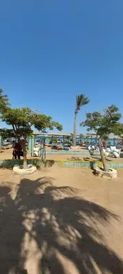 two palm trees in a park with a playground at Golden Tiba in Hurghada