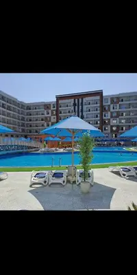 a group of chairs and umbrellas next to a pool at Golden Tiba in Hurghada