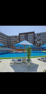 a group of chairs and umbrellas next to a pool at Golden Tiba in Hurghada
