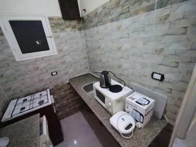 a kitchen with a sink and a microwave on a counter at Peaceful Private Studio Steps from Luxor in Luxor