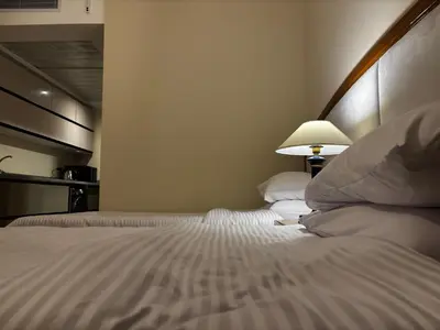 a bedroom with a large bed with a lamp on it at Prime Square Aldau Heights in Hurghada