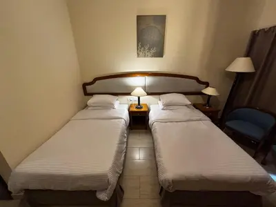 two beds in a hotel room with two lamps at Prime Square Aldau Heights in Hurghada