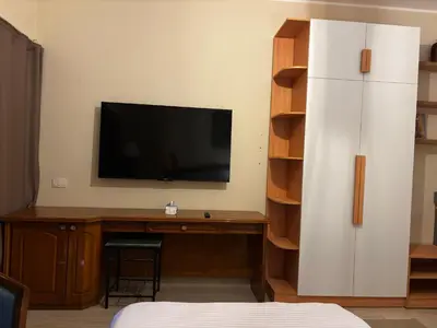 a room with a desk with a television and a white refrigerator at Prime Square Aldau Heights in Hurghada