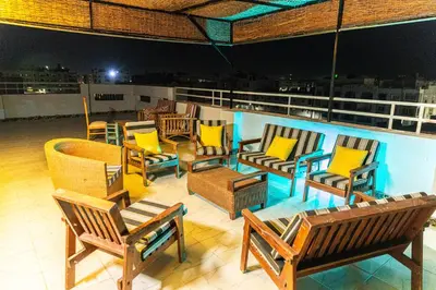 a group of chairs and tables on a balcony at night at Sultan's Suite-Chill Out Roof Terrace-3 Bedrooms in Hurghada