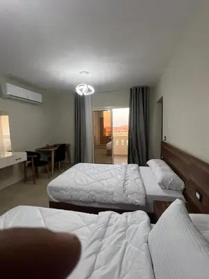 a hotel room with two beds and a desk at Studio in Nubia Aqua Beach Twin Room in Hurghada in Hurghada