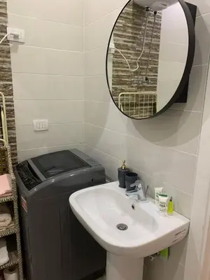 a bathroom with a sink and a mirror and a trashcan at Schöne Hotel -Apartment in Sky El Gandoul Hurghada in Hurghada