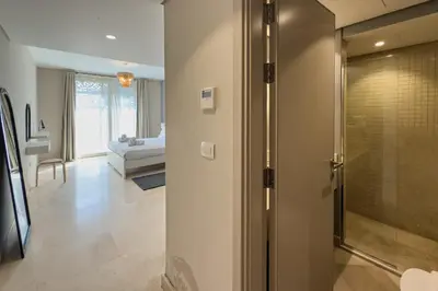 a bathroom with a walk in shower and a bedroom at The Platinum Perch 2BDR Pool View Free Pool & Beach Access in Hurghada