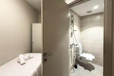 a small bathroom with a bed and a toilet at The Platinum Perch 2BDR Pool View Free Pool & Beach Access in Hurghada