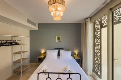 a bedroom with a bed and a chandelier at The Platinum Perch 2BDR Pool View Free Pool & Beach Access in Hurghada