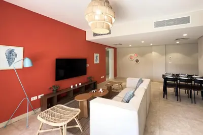 a living room with a couch and a dining room at The Platinum Perch 2BDR Pool View Free Pool & Beach Access in Hurghada