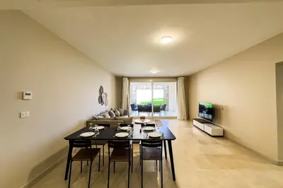 a living room with a table and a couch at The Golden Atrium 3BDR Pool View Free Pool & Beach Access in Hurghada