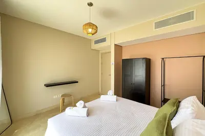 a bedroom with a large bed with two towels at The Golden Atrium 3BDR Pool View Free Pool & Beach Access in Hurghada