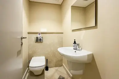 a bathroom with a white toilet and a sink at The Golden Atrium 3BDR Pool View Free Pool & Beach Access in Hurghada