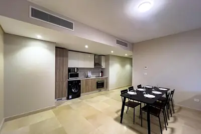 a dining room with a table and a kitchen at The Golden Atrium 3BDR Pool View Free Pool & Beach Access in Hurghada
