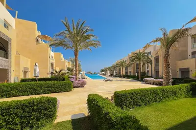 a resort courtyard with palm trees and a swimming pool at The Golden Atrium 3BDR Pool View Free Pool & Beach Access in Hurghada