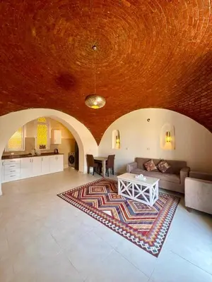 a living room with a couch and a table at Royal Home Dome Style - Ground Floor Apartment in Jazīrat al ‘Awwāmīyah