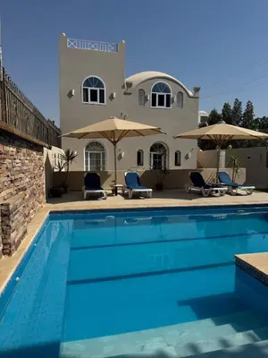 a swimming pool in front of a villa at Royal Home Dome Style - Ground Floor Apartment in Jazīrat al ‘Awwāmīyah