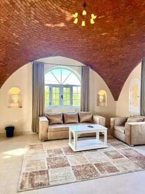 a living room with a couch and a table at Royal Home Dome Style - Top Floor Apartment in Jazīrat al ‘Awwāmīyah