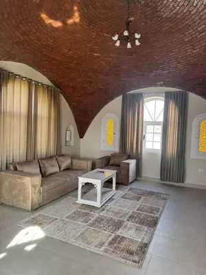 a living room with a couch and a table at Royal Home Dome Style - Top Floor Apartment in Jazīrat al ‘Awwāmīyah