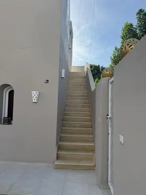 a stairway leading up to a white building with stairs at Royal Home Dome Style - Top Floor Apartment in Jazīrat al ‘Awwāmīyah
