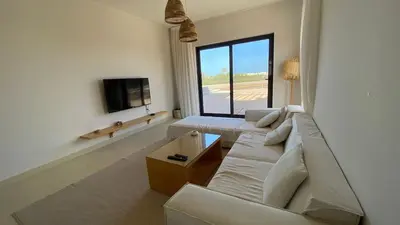 a living room with a white couch and a tv at Gouna 3 bedrooms townhouse cyan in Hurghada