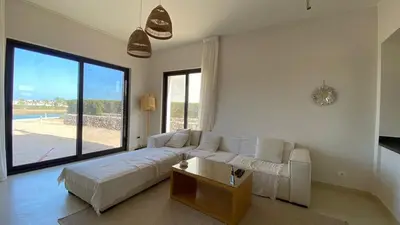 a living room with a white couch and a large window at Gouna 3 bedrooms townhouse cyan in Hurghada