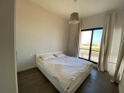 a white bedroom with a bed and a large window at Gouna 3 bedrooms townhouse cyan in Hurghada