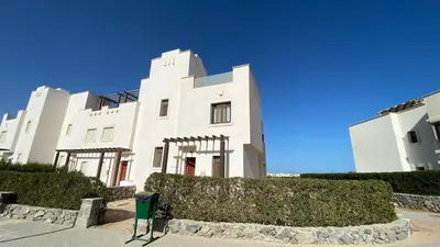 a white building with a hedge in front of it at Gouna 3 bedrooms townhouse cyan in Hurghada