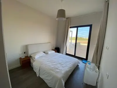 a bedroom with a white bed and a large window at Gouna 3 bedrooms townhouse cyan in Hurghada