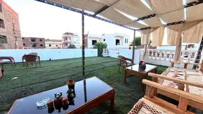 a patio with tables and chairs on a roof at Celia Guest House in Luxor