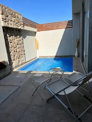 a pair of chairs sitting next to a swimming pool at One Bedroom private pool in Hurghada
