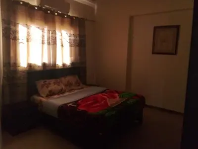 a bed in a bedroom with a window with lights at The Horizon House in Luxor