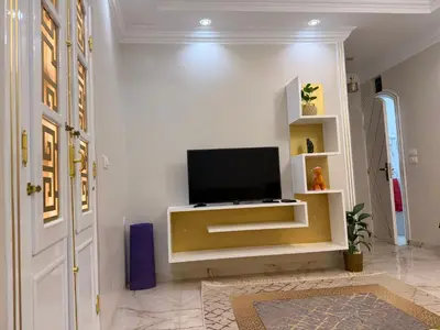 a living room with a flat screen tv on a wall at Oscar Apartment 8 in Luxor