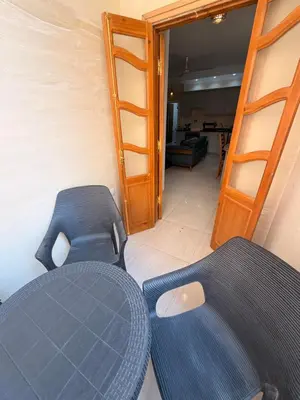 two blue chairs in a room with a open door at Oscar Apartment 10 in Luxor