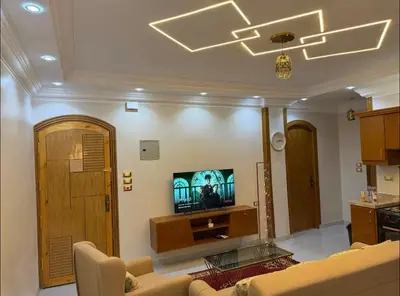 a living room with a couch and a tv at Oscar Apartment 10 in Luxor