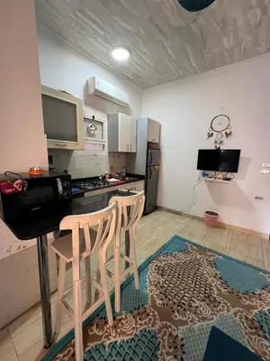 a kitchen with two chairs and a table and a counter at one bedroom at magawish hurghada in Hurghada