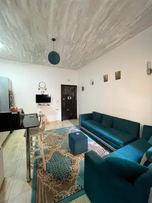 a living room with a blue couch and a table at one bedroom at magawish hurghada in Hurghada