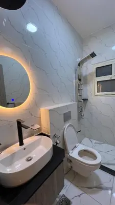 a white bathroom with a toilet and a sink at شقة فندقية امام المارينا 3 غرف 5 سراير in Hurghada
